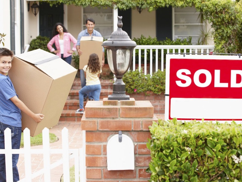 sold-sign-in-front-of-house-with-family-moving-boxes-inside_123948